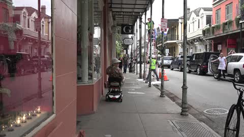 New Orleans man on scooter watches workers