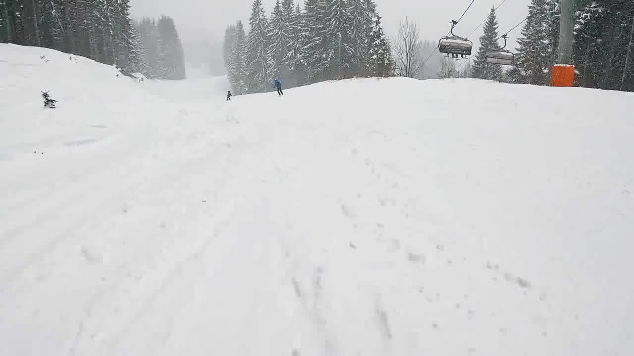 Low angle POV Shot Of Skier Skiing Down Misty Snow Covered Slope 2