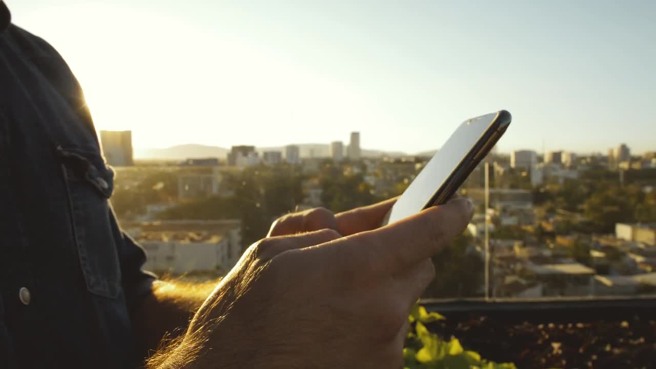 Guy texting at sunset