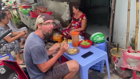 Foreign tourists are trying street food in Vietnam