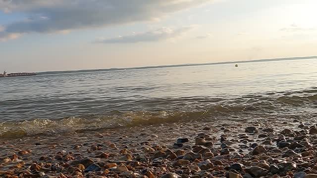 Calm waves hitting the shore. On a sunny day. GoPro