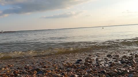 Calm waves hitting the shore. On a sunny day. GoPro