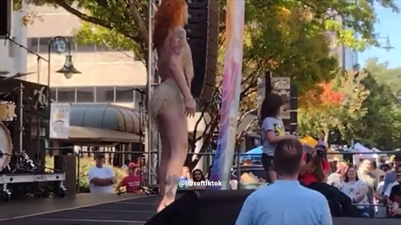 A drag queen teaches young child to perform & collect cash tips at a pride event in South Carolina