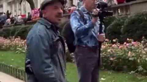 Man yells at an elderly couple holding posters of Israeli civilians kidnapped by Hamas.