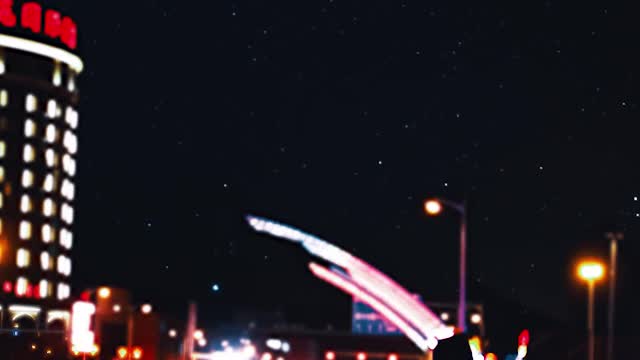 A Man Walking By The Roadside In The City At Nighttime