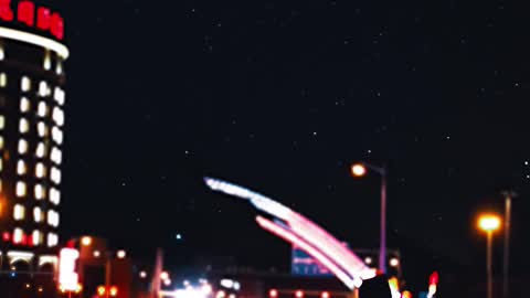 A Man Walking By The Roadside In The City At Nighttime