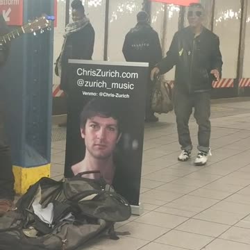 Guy in black jacket dances next to subway singer
