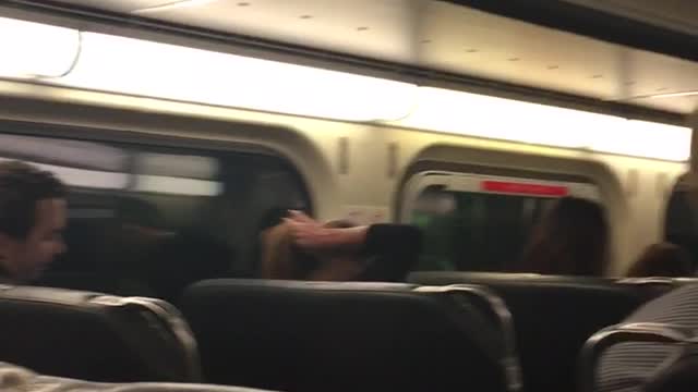 A guy with spiky red blonde hair sitting on train