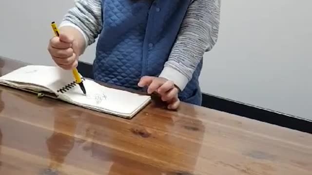 This is a video of a baby studying while writing something hard.