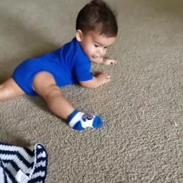 Baby Boy Spins Around Floor Chasing His Foot