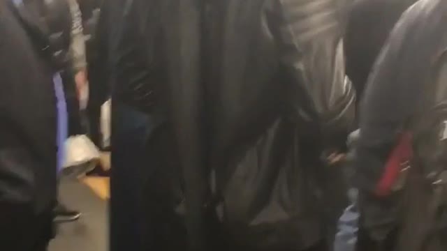 Guy in hoodie wears samurai sword in subway terminal