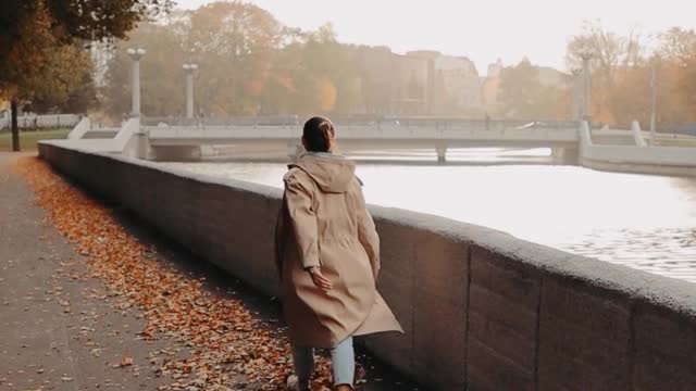 Woman Walking Over the Dried Leaves by the River