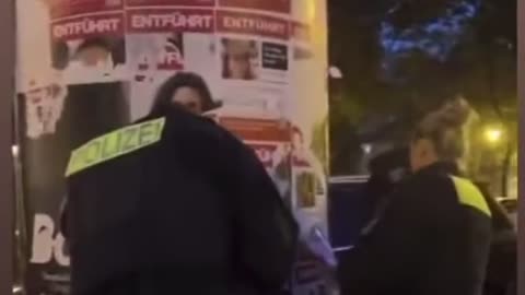 German police officers destroying poster of Israeli civilians kidnapped by Hamas.