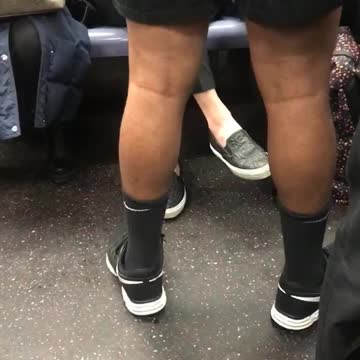 Man wears jacket and shorts on subway