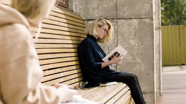 A Women Stead On The Bench With Her Books
