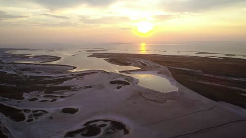 Shore of a huge lake from above at sunset