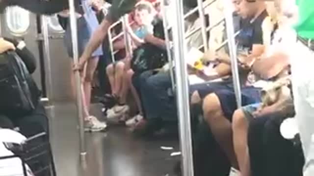 Guy green shirt dancing flips train subway pole