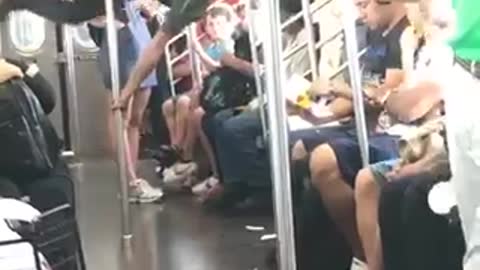 Guy green shirt dancing flips train subway pole