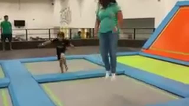 Lady jumping trampoline guy tackle