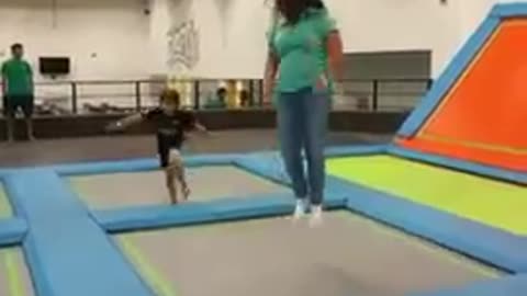 Lady jumping trampoline guy tackle