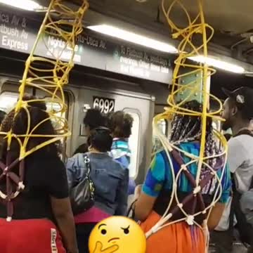 Two people with wire giraffes on their back