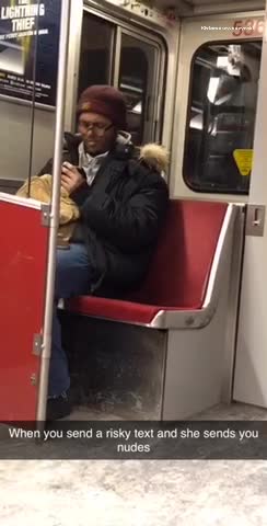 Guy wearing earphones headbangs to music on subway train