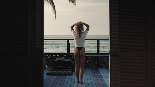 Woman taking in the ocean view from her hotel room