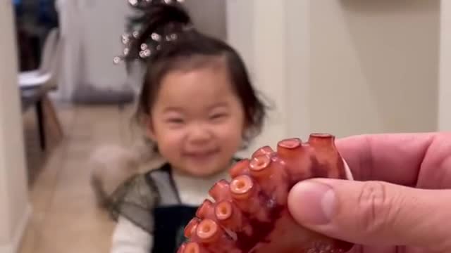 Will the cute baby eat the octopus leg