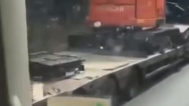 Lorry knocks digger off of trailer by hitting bridge