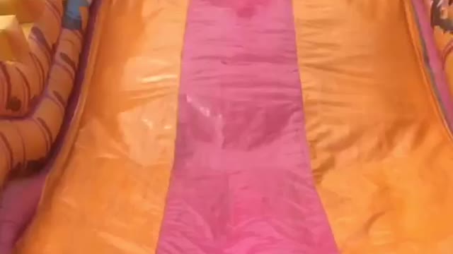 Little kid jumps down yellow and pink slide and hits face