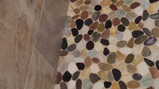 Custom Shower. Stone waterfall coped feature with stone shower floor with schluter drain.