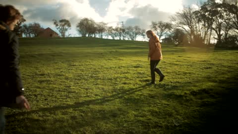 Young Couple Walking Dog at Sunset