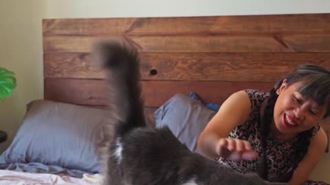 A Woman With Her Cat On Her Bed