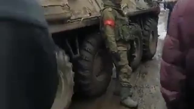 Ukrainian civilians signing the Ukrainian anthem in front of Russian soldier in Konotop