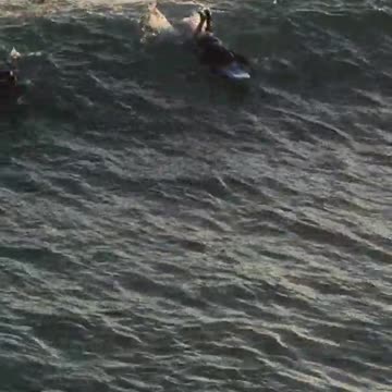 Man on surf board kicking on wave