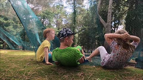 Children Relaxing On A Net In The Park