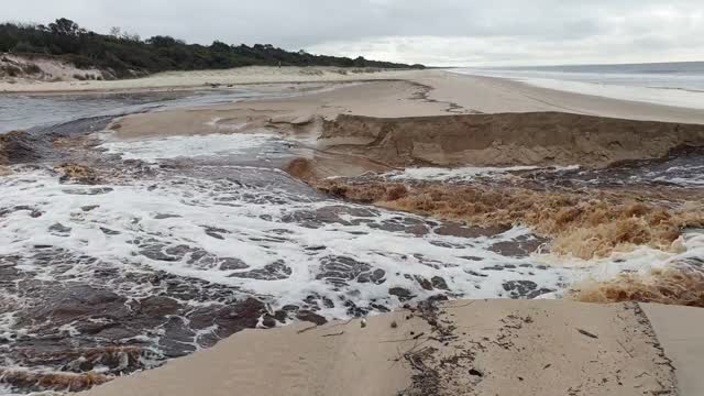 Lagoon Breaks Through the Sand Into the Sea