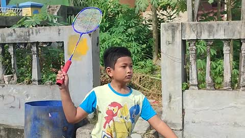 A kid plays Badminton in the outdoor