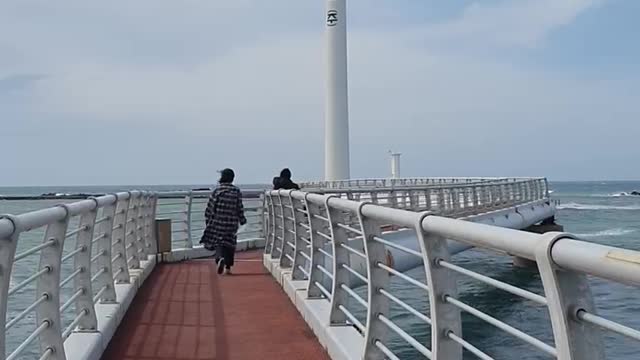 Windmill in Jeju Island windmill. beach. Wave.