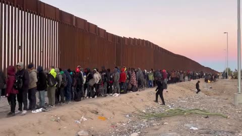 Thousands wait to cross the "border" into America.