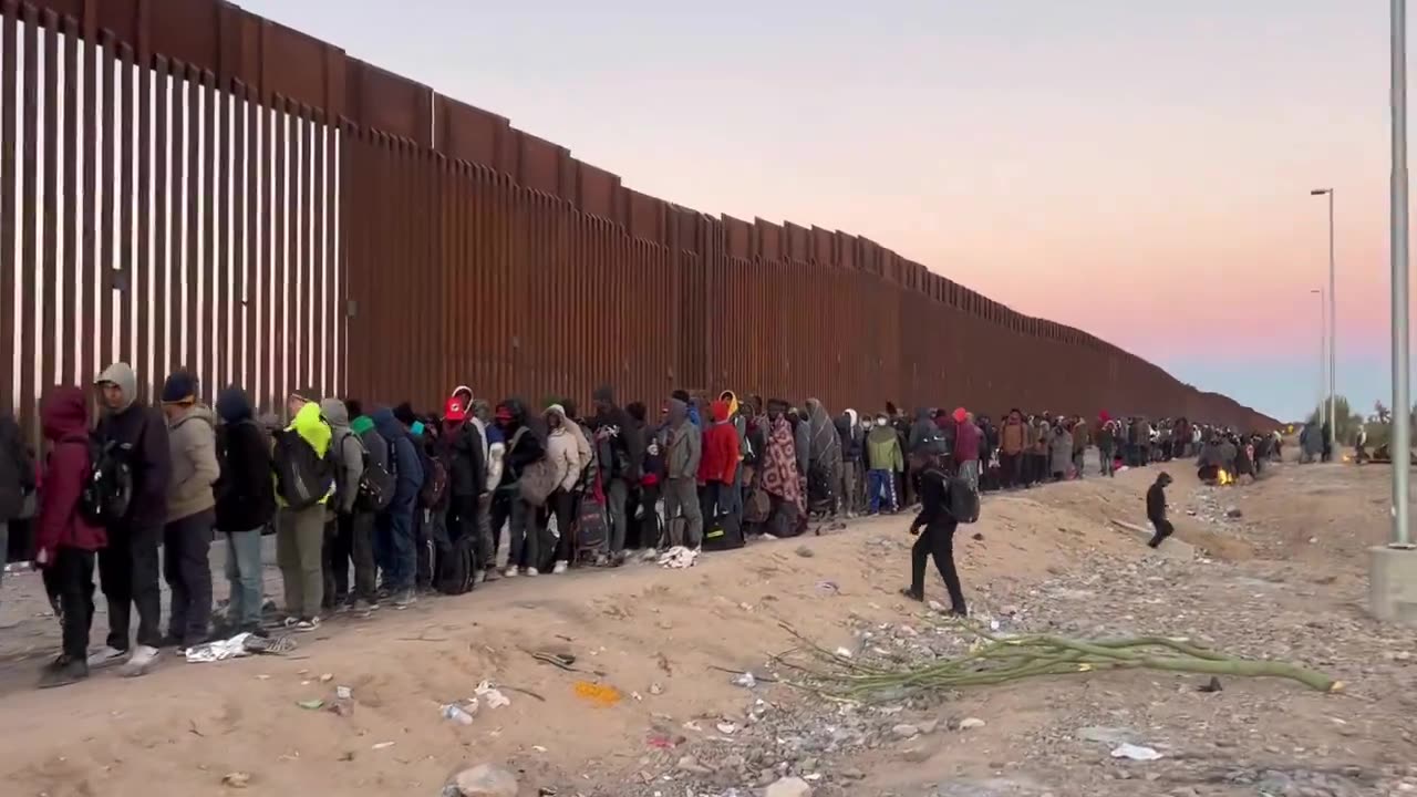 Thousands wait to cross the "border" into America.