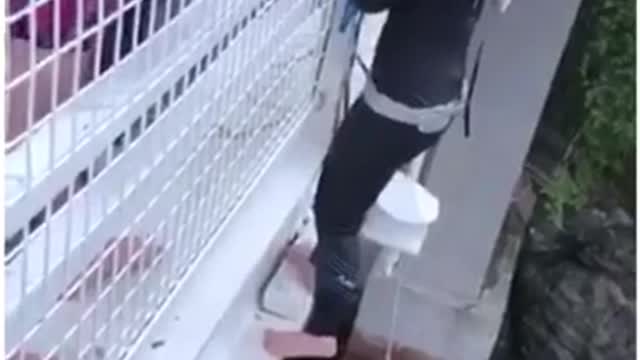 Black wetsuit girl jumps off white bridge to swing from rope and faceplants