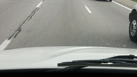 Police Car Rides in Two Lanes on Highway