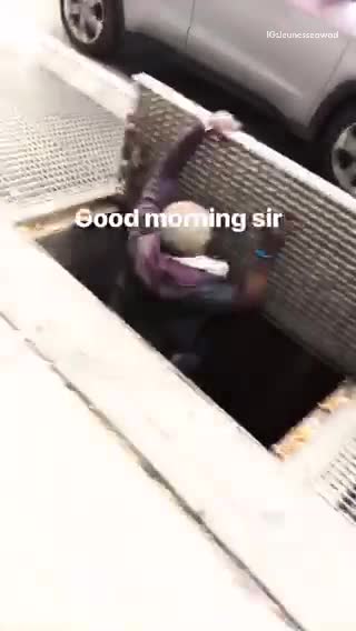 Man crawling into vent on the street
