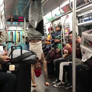 Man with red beanie rides subway does tricks