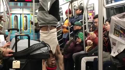 Man with red beanie rides subway does tricks