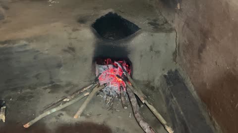 Dayalu Baba Shows Us His Mud Stove at the Ashram