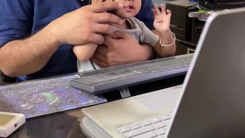 Cute baby picks up mouse as a phone