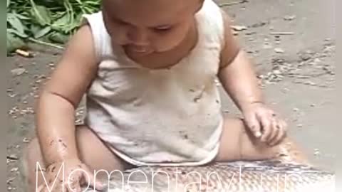 Cute baby playing with a big size catla fish