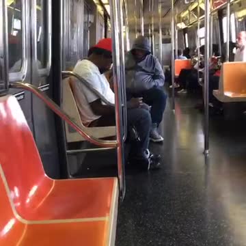 Man switching blue and red hats on train